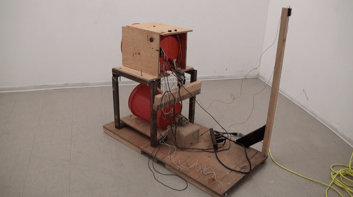 Kinetic sculpture 'Drumb' by Nevada Hardman. A mechanical percussion-based work made of wood, metal, solenoids, and a button.